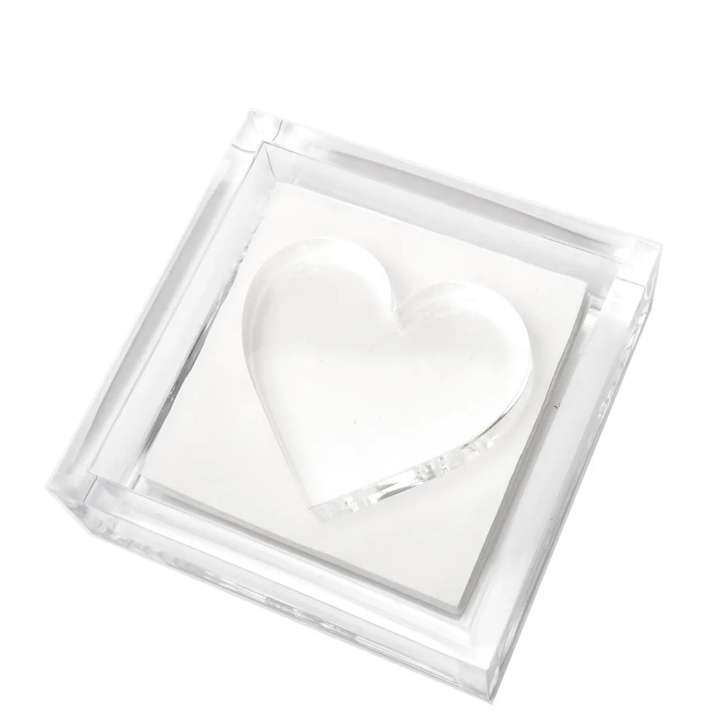 Clear heart-shaped object in a transparent lucite napkin holder