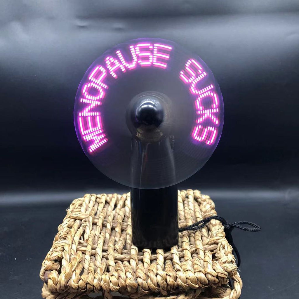 A novelty handheld fan featuring pink LED text that reads 'MENPAUSE SUCKS' 